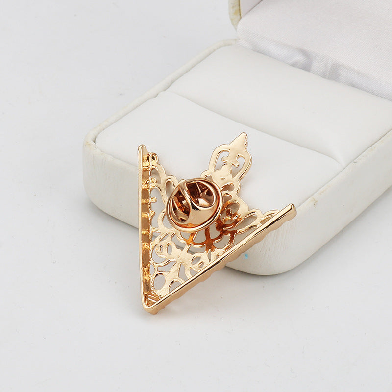 Gold triangular shirt collar clip brooch with curved clasp and ornate filigree back