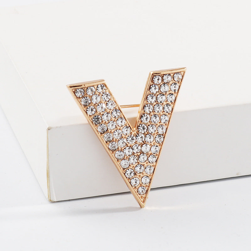 Gold V-shaped rhinestone collar pin with pin bar clasp, faceted stones