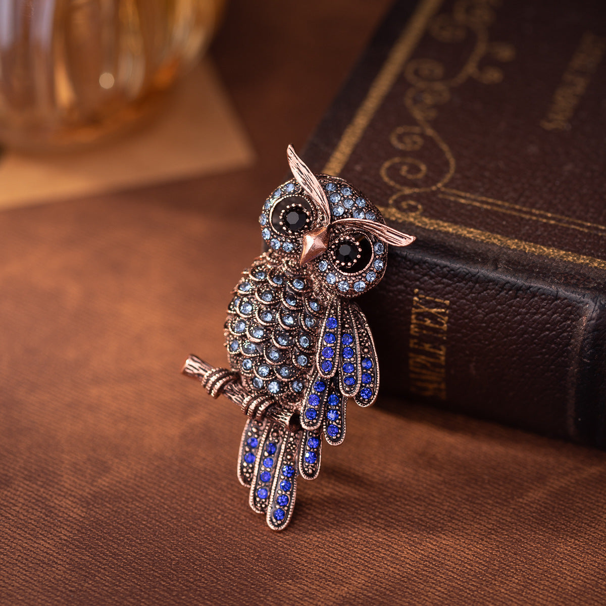Blue owl brooch in profile, round rhinestone eyes and blue enamel wing pattern