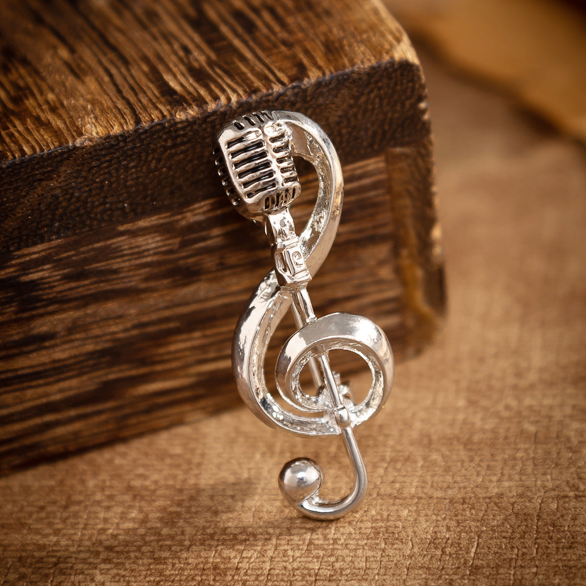 Silver microphone music-note brooch pin, curled hook back, close-up