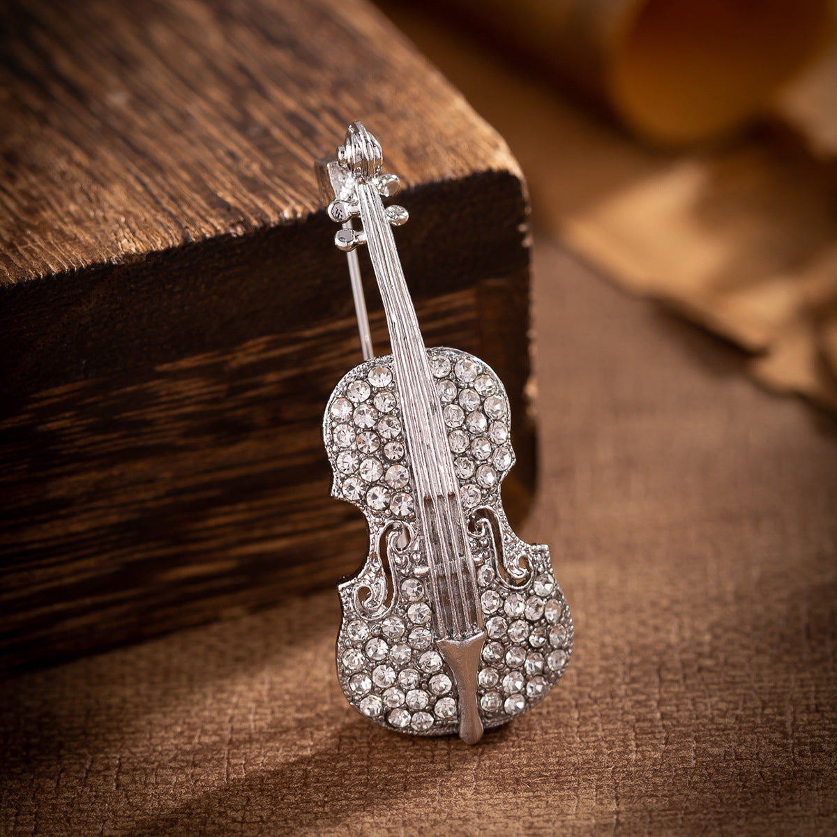 Silver-tone guitar brooch with rhinestone inlaid strings and ornate body