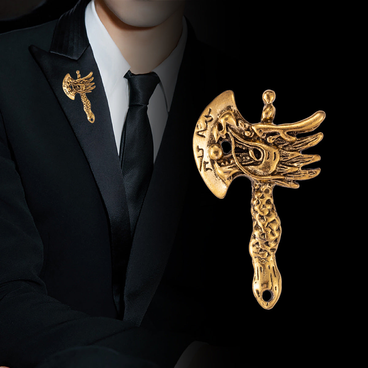 Gold dragon head axe brooch with winged details and long textured handle