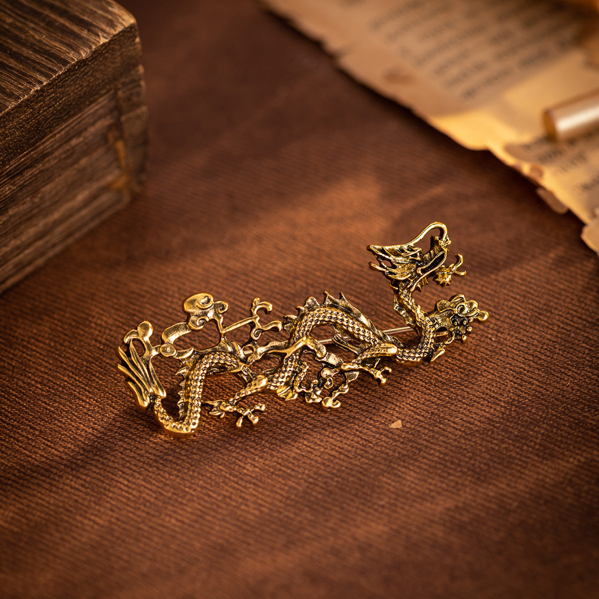 Gold dragon totem brooch with raised scales and curling tail