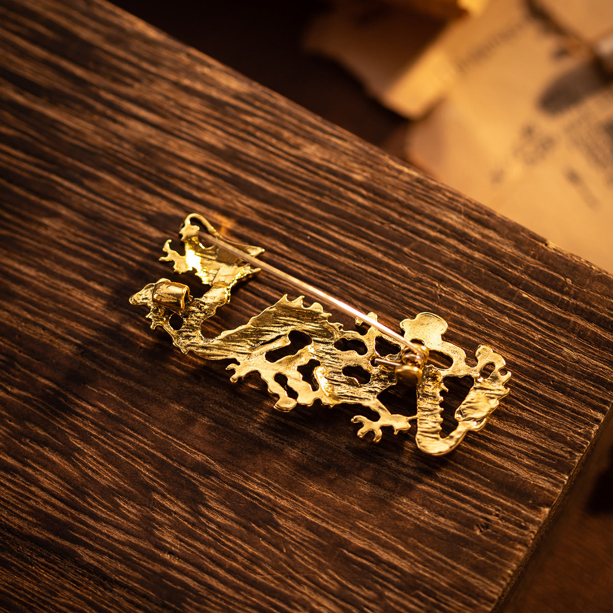 Gold Chinese dragon totem brooch, flat ornate design with clasp pin