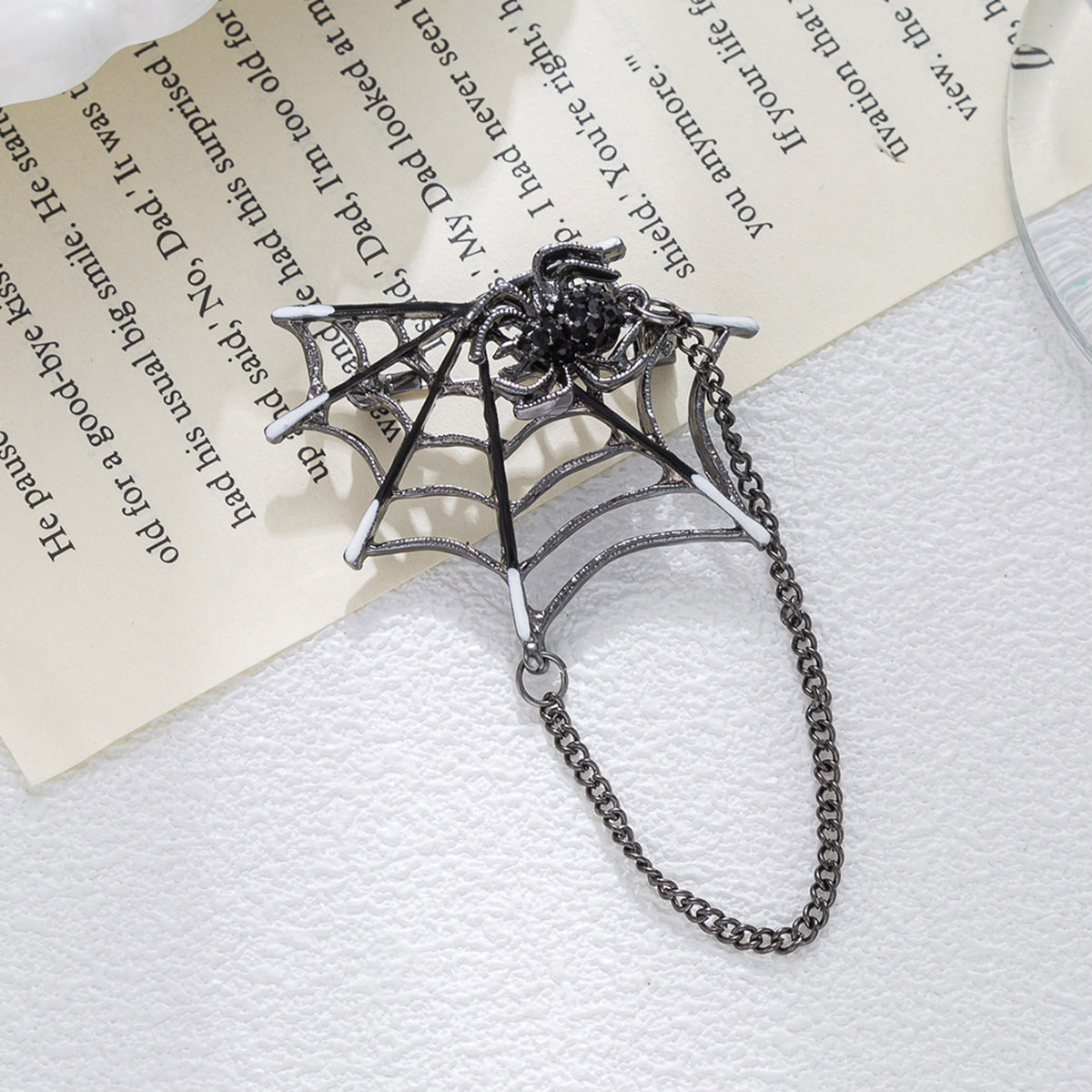 Silver spider-web brooch with black rhinestone spider and linked chain