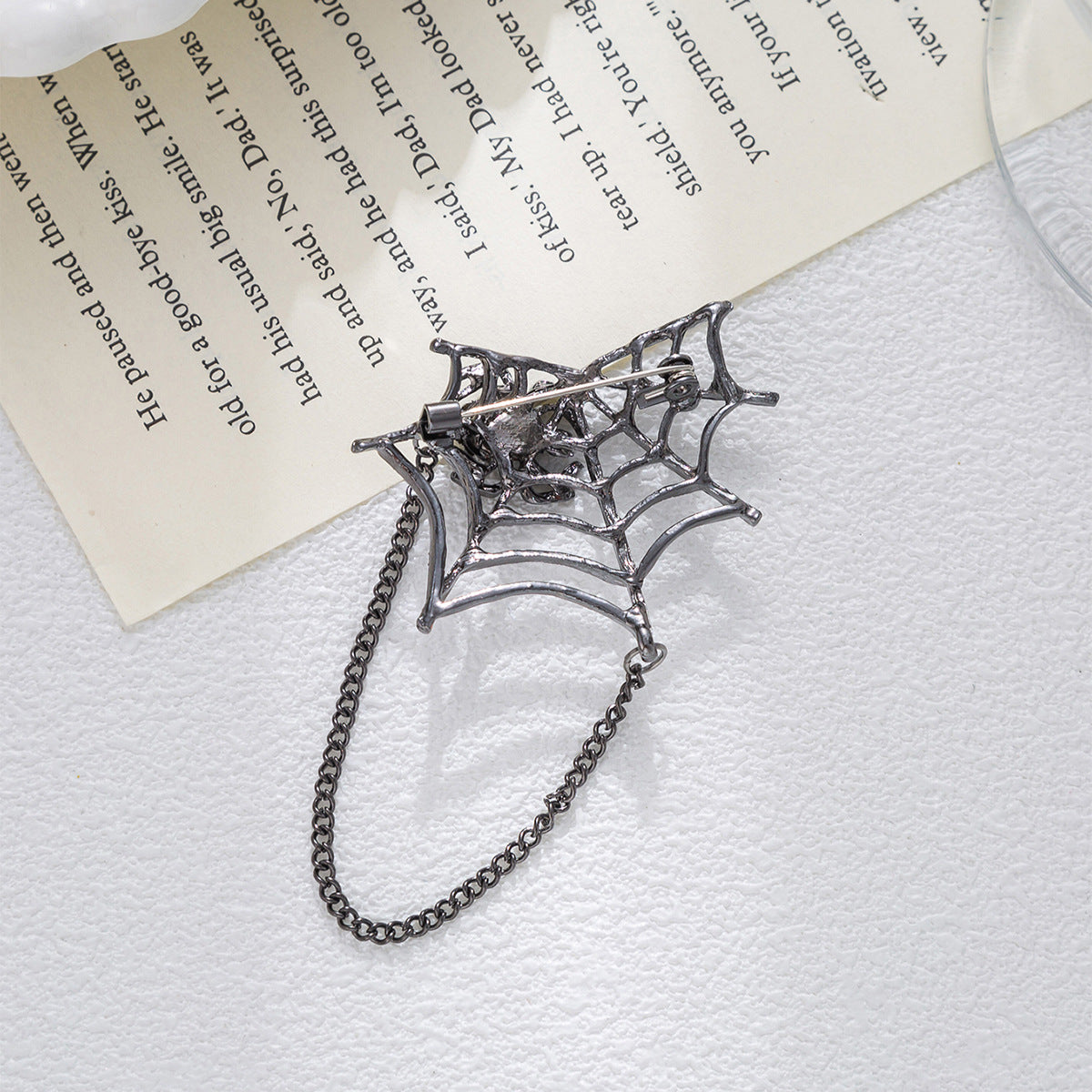 Silver spider-web brooch with rhinestone spider center and long hanging chain