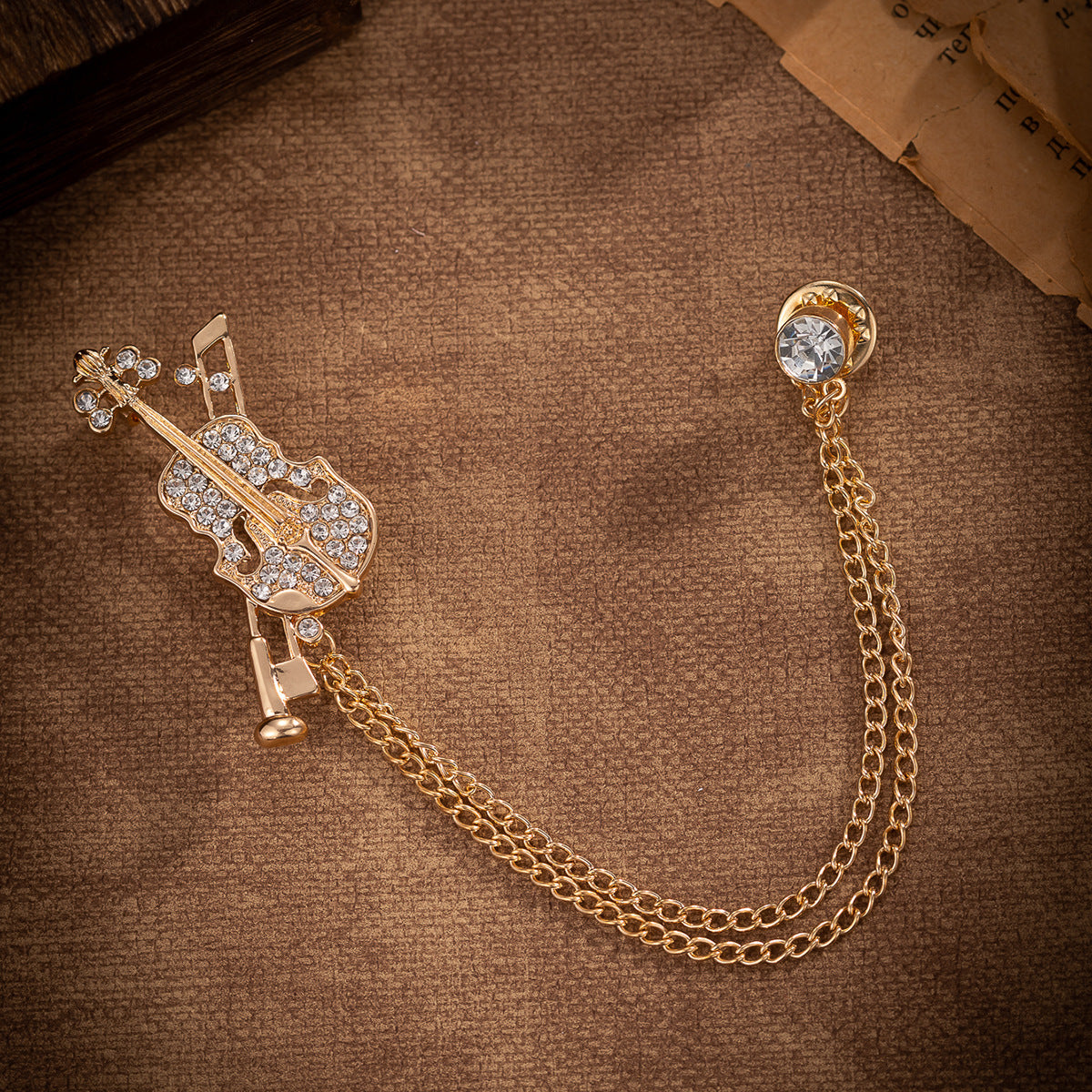 Gold-tone violin brooch tassel badge with rhinestone violin head and round crystal clasp