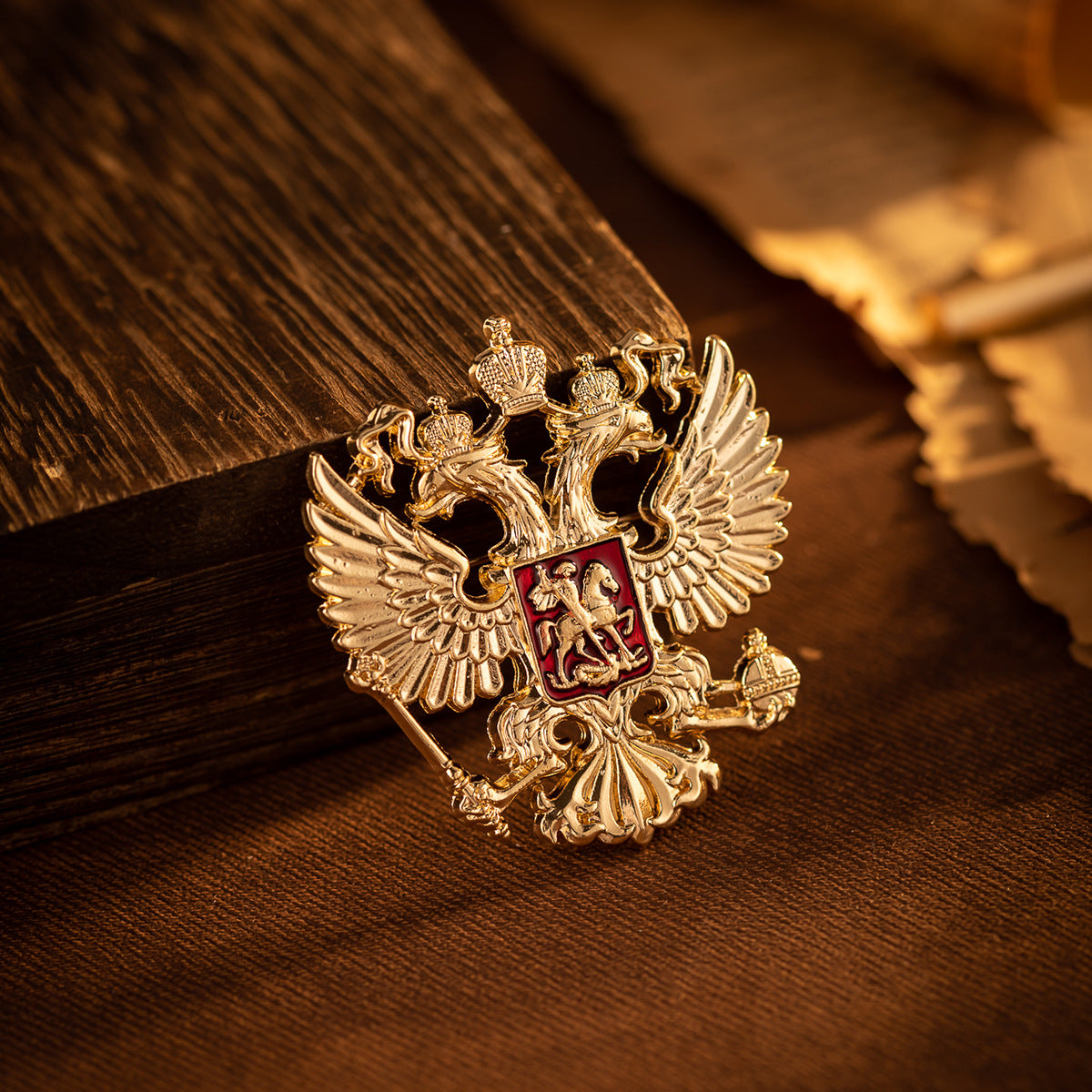 Gold-tone double-headed eagle knight brooch pin with red crest, on dark fabric