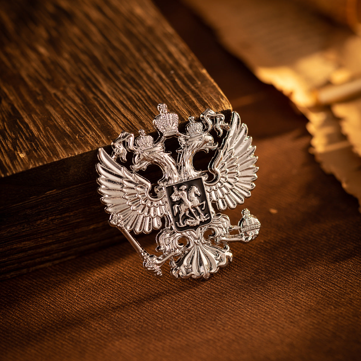 Silver-tone double-headed eagle knight brooch pin with crest details on dark fabric