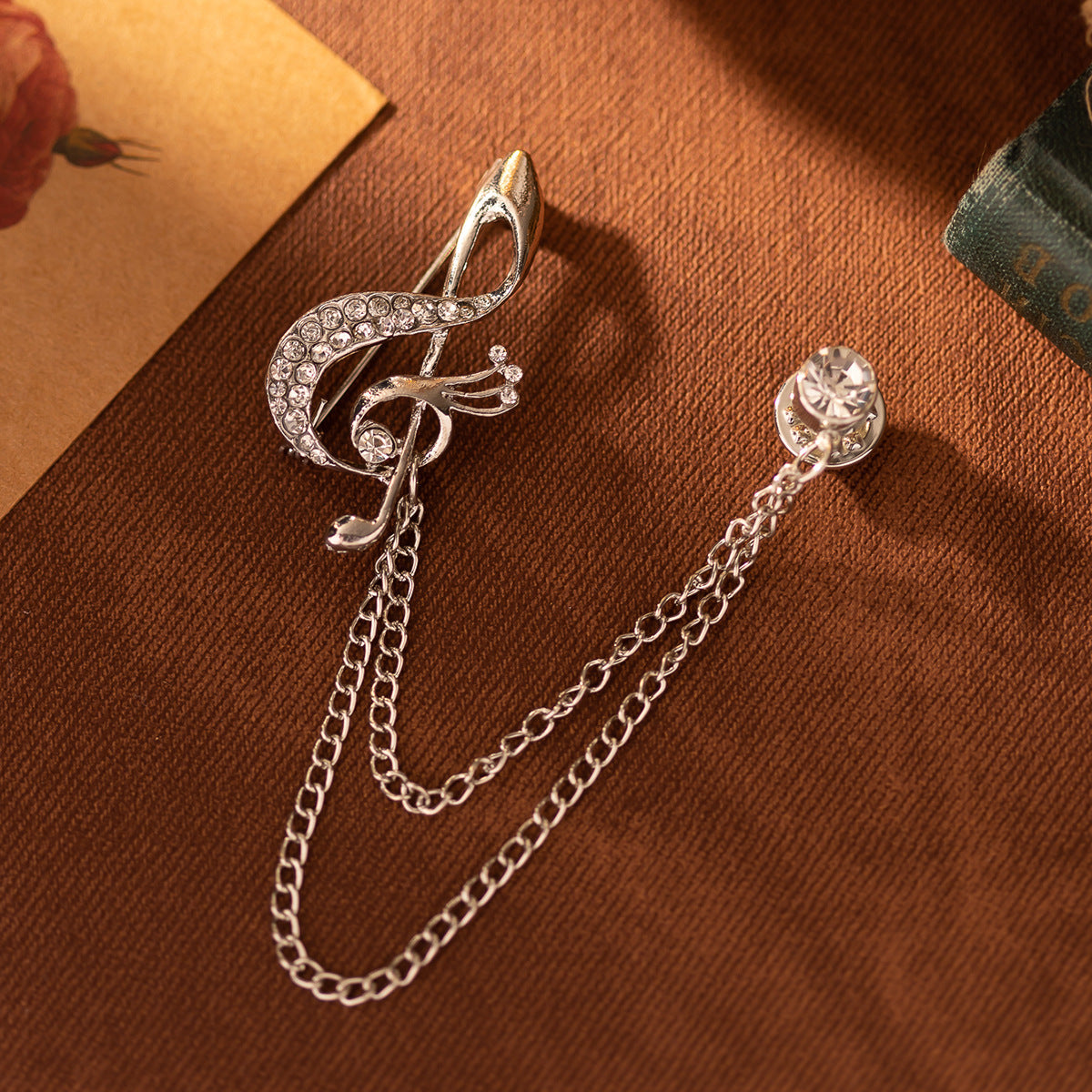 Silver-tone musical note chain brooch with rhinestone crescent and round stone charm