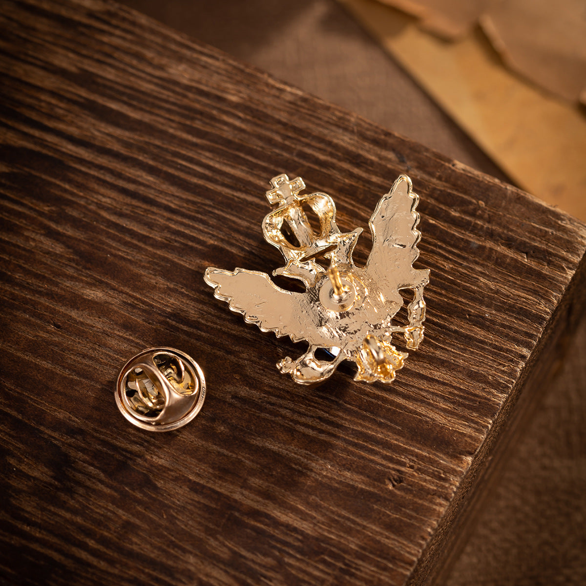 Gold eagle brooch back: pin post and clasp; crown and wing setting with dark stone