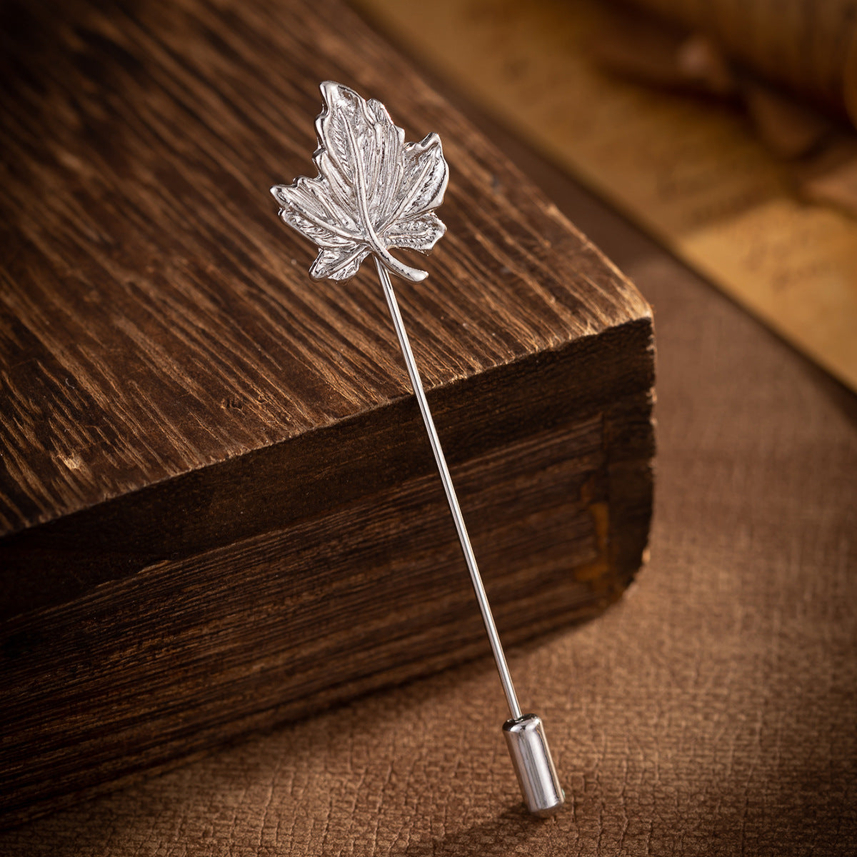 Silver-tone maple leaf brooch pin with textured leaf veins and straight post