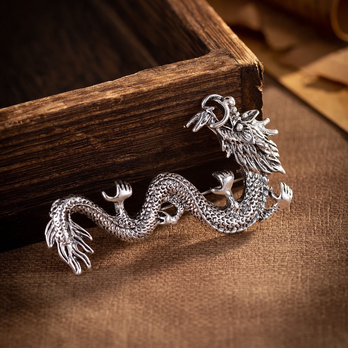 Dragon zodiac totem brooch in antique silver with detailed scales and claws