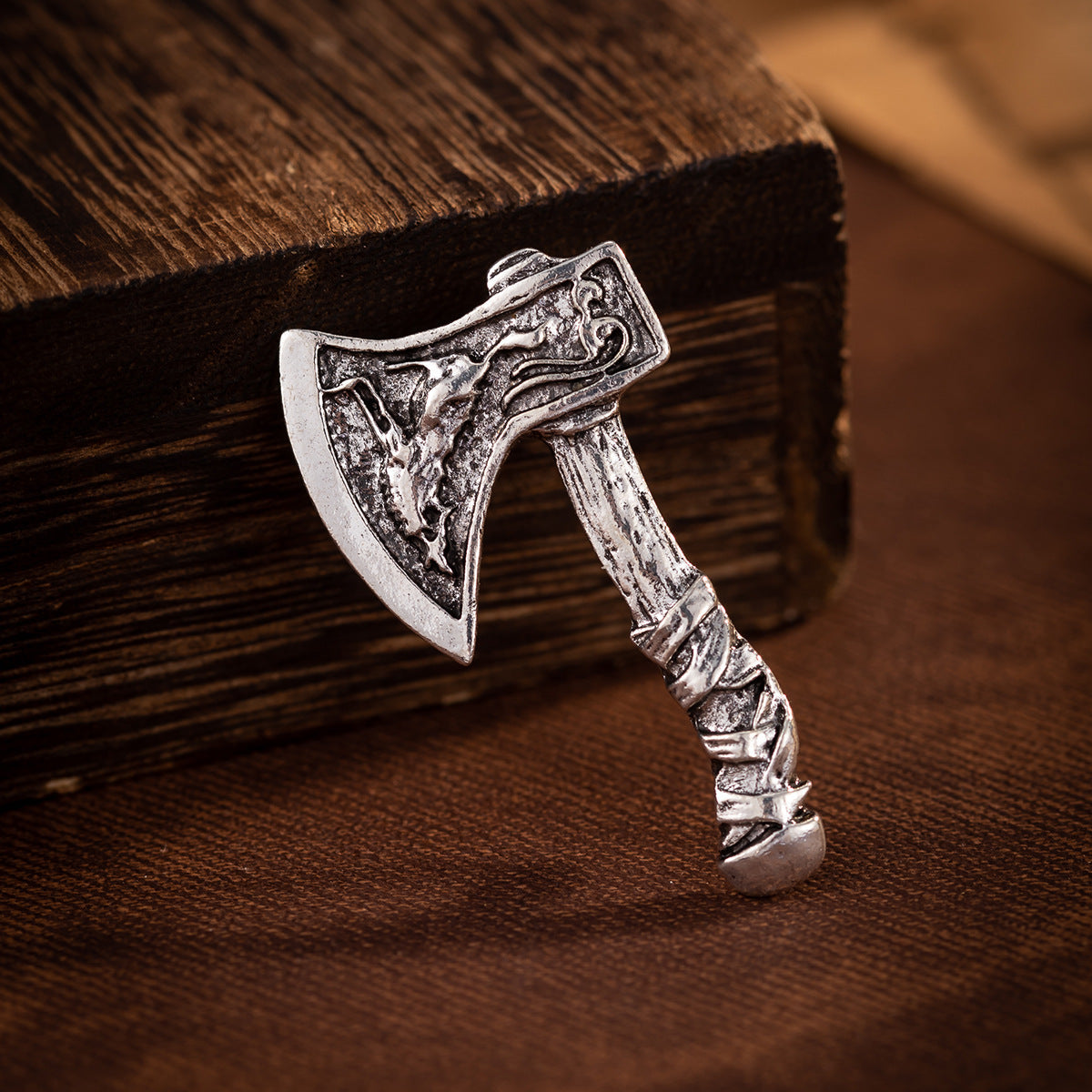 Silver axe brooch close-up, ornate head and ribbed handle