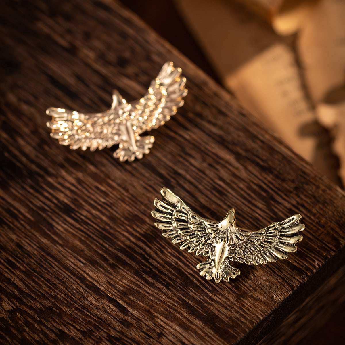 Gold-tone eagle badge brooch, angled view highlighting wing details and pin clasp