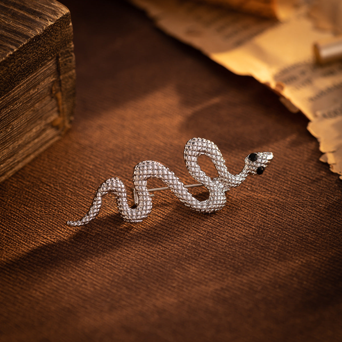 Silver snake lapel pin with raised scale pattern and black eyes