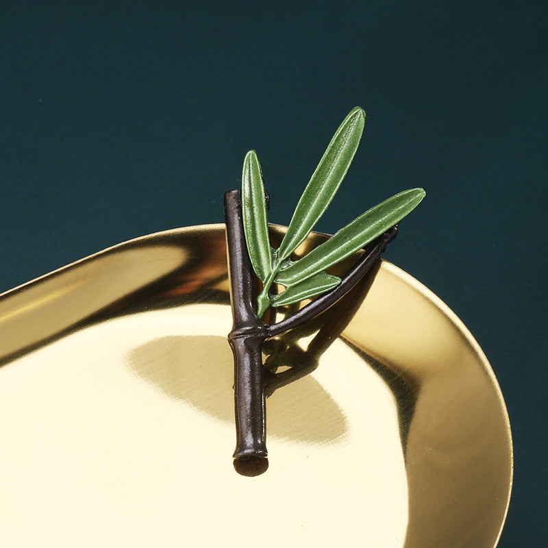 Green 3D leaf brooch pin with dark stem and three upright green leaf leaves