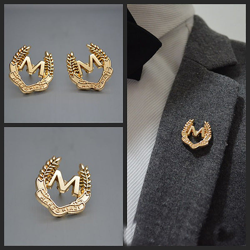 Set of gold M brooches with wheat ear wreath detail, shown from multiple angles