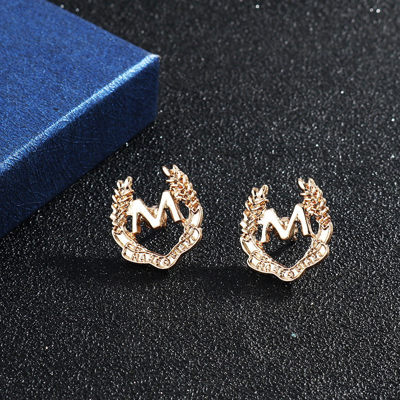 Two gold M wheat ear brooches, raised wreath detailing and cutout center