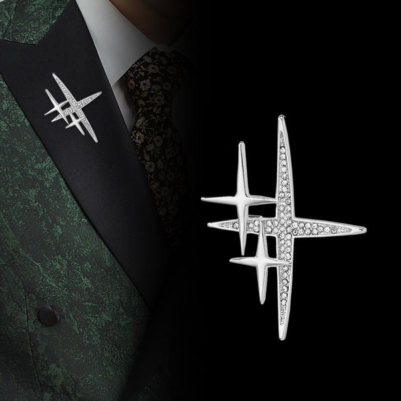 Silver cross-shaped starburst brooch pin with rhinestone details and clasp