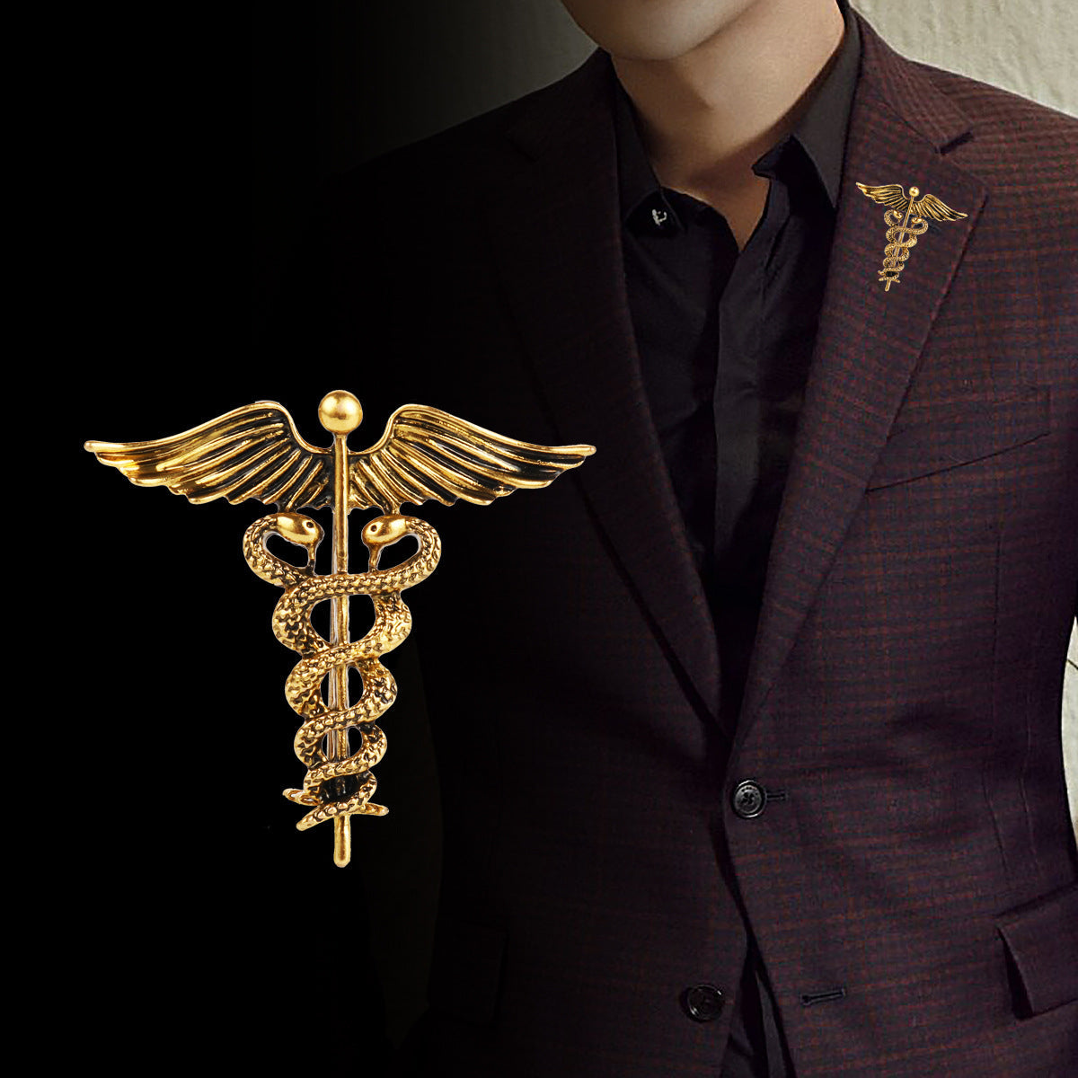 Gold angel wings and snake caduceus brooch pin on a dark suit lapel
