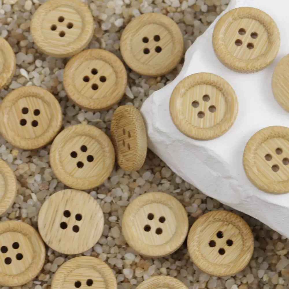 Mixed natural bamboo round buttons with four holes, assorted sizes on a tray