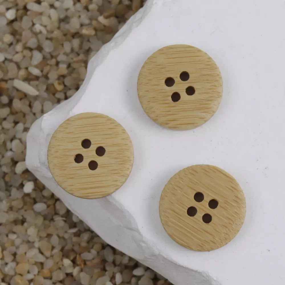 Set of natural bamboo round buttons with four holes on a white card