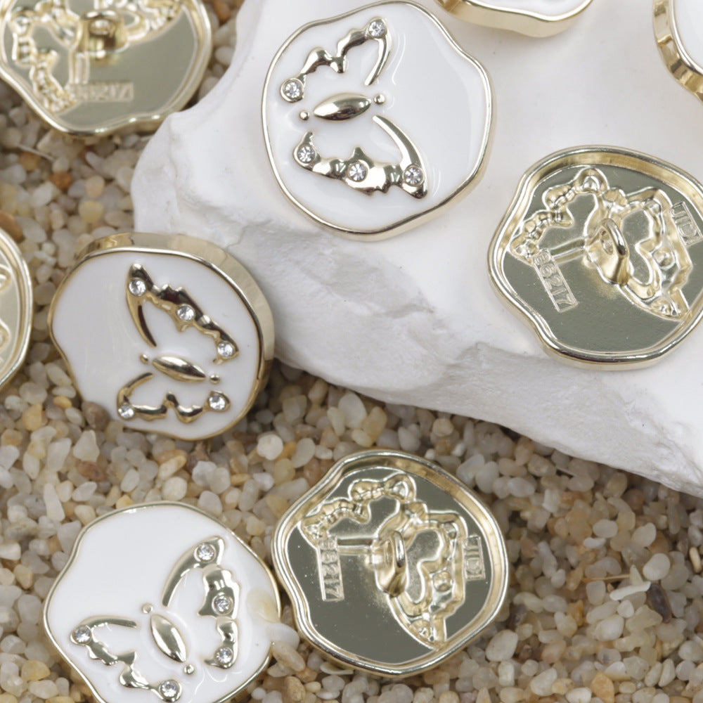 Butterfly metal shank buttons with gold-tone frames on white and dark bases