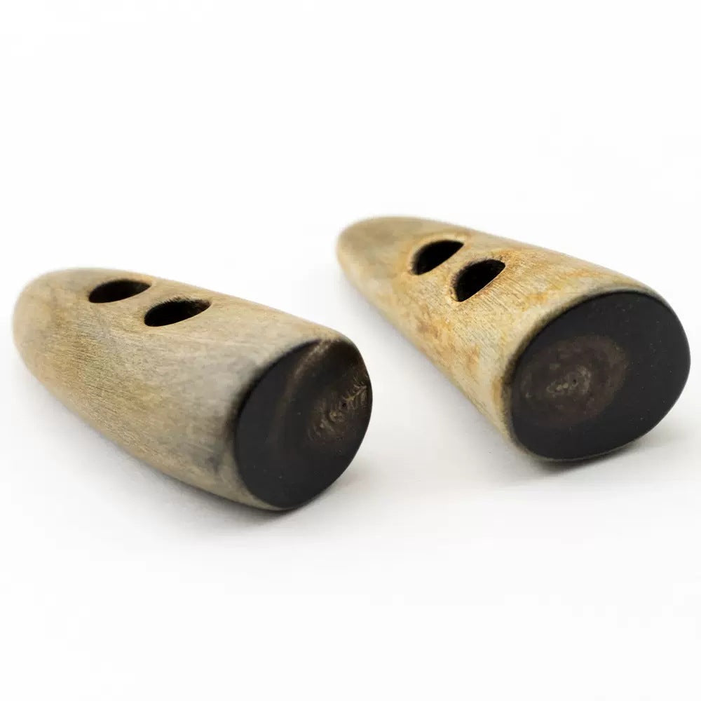 Two horn-look toggle buttons, burnt tan, oval ends with three cutouts