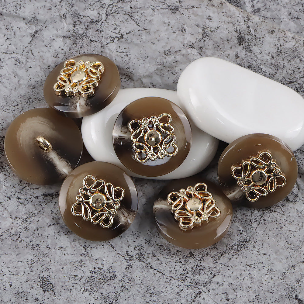 Round metal-and-resin buttons with shanks, gold-tone clover filigree on brown and amber tones