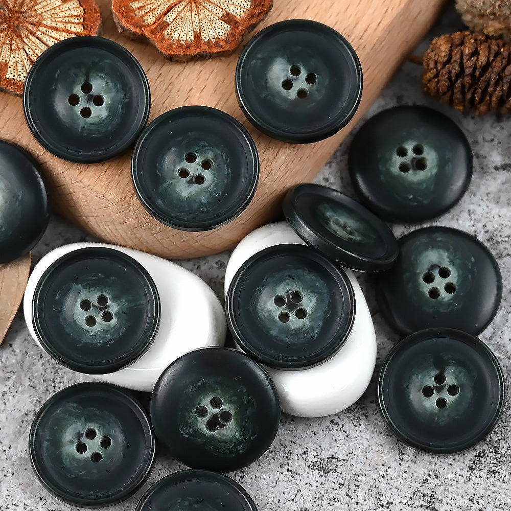 Round 4-hole urea buttons in dark green and black tones with one white button
