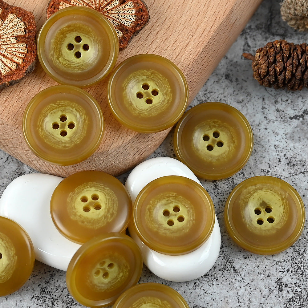 Round 4-hole urea buttons in mustard yellow, golden brown, and white mix