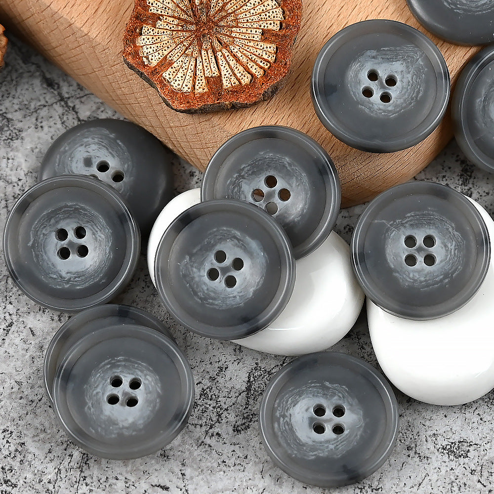 Round 4-hole urea buttons in gray and dark charcoal tones with two white buttons