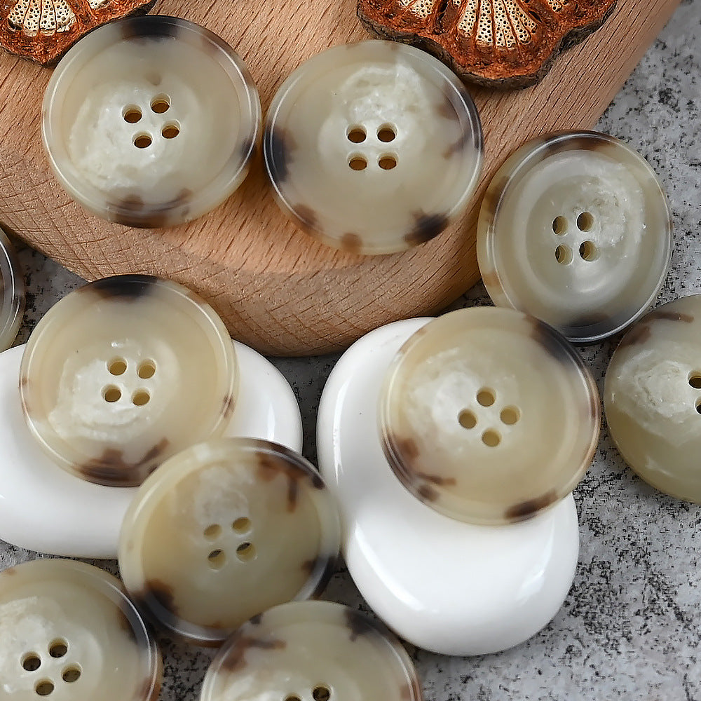 Round 4-hole urea buttons, cream with subtle marbled beige tones