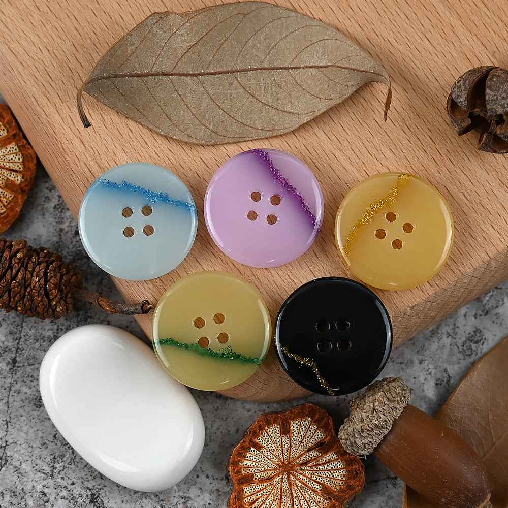 Round 4-hole urea buttons: light blue, lilac purple, pale yellow-green, and black