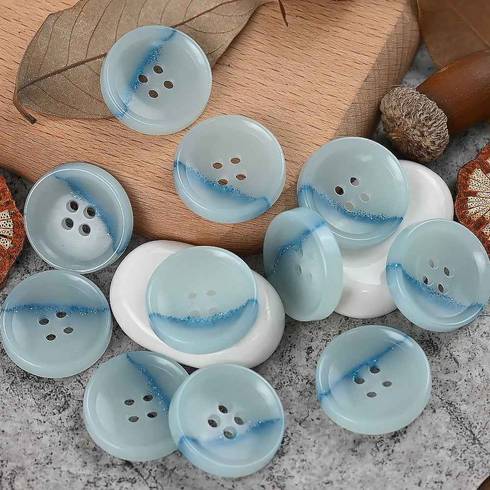 Round 4-hole urea buttons in sky blue with sparkling blue streak detail