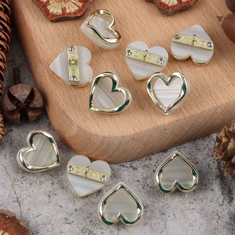 Heart-shaped resin metal shank buttons, white/cream faces with shiny chrome heart frame