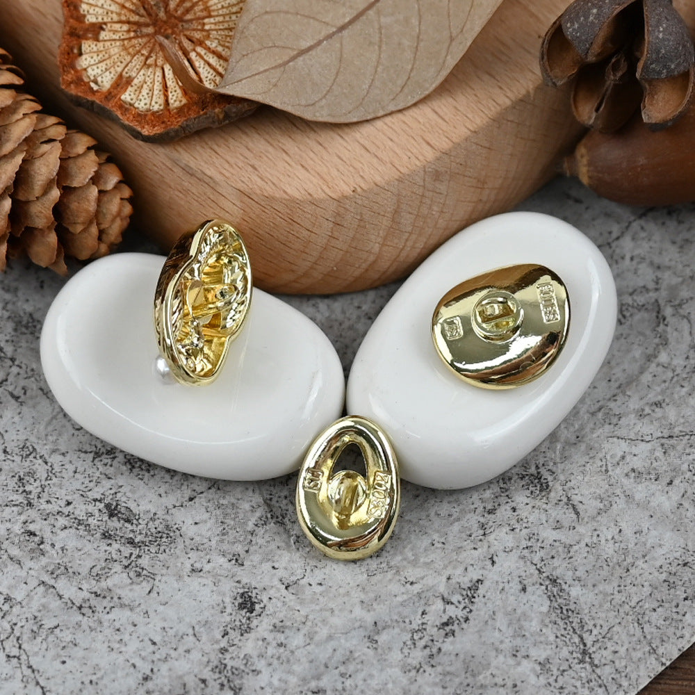 Oval gold shank buttons with white pearl center and ribbed insert, 2-piece close-up