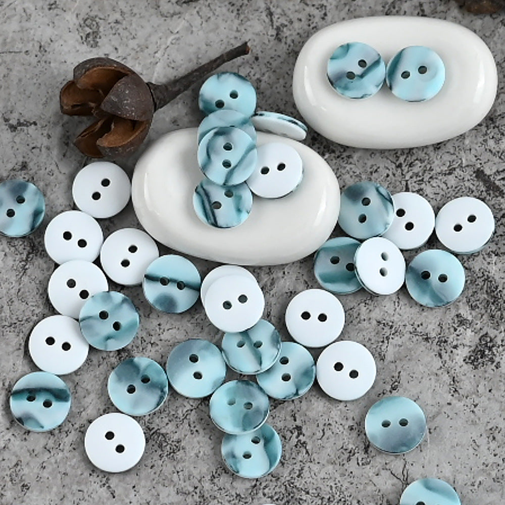 Assorted 11mm resin shirt buttons in light blue and white, round four-hole faces