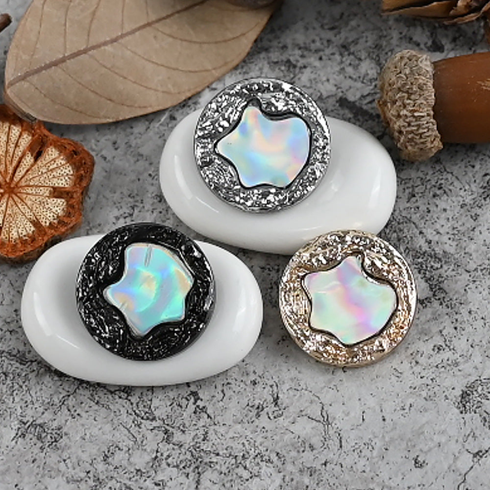 Shank buttons on white base: silver, black, and gold glitter frames with iridescent centers