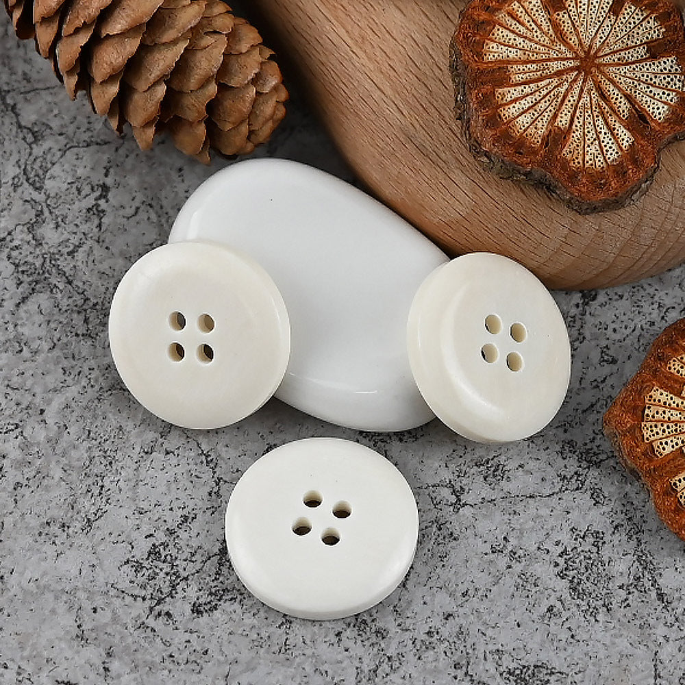 White round 4-hole buttons, top view showing four holes on the button face