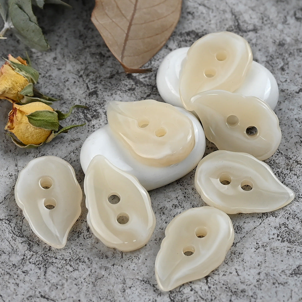 Beige/cream irregular leaf-shaped resin buttons, each with two holes