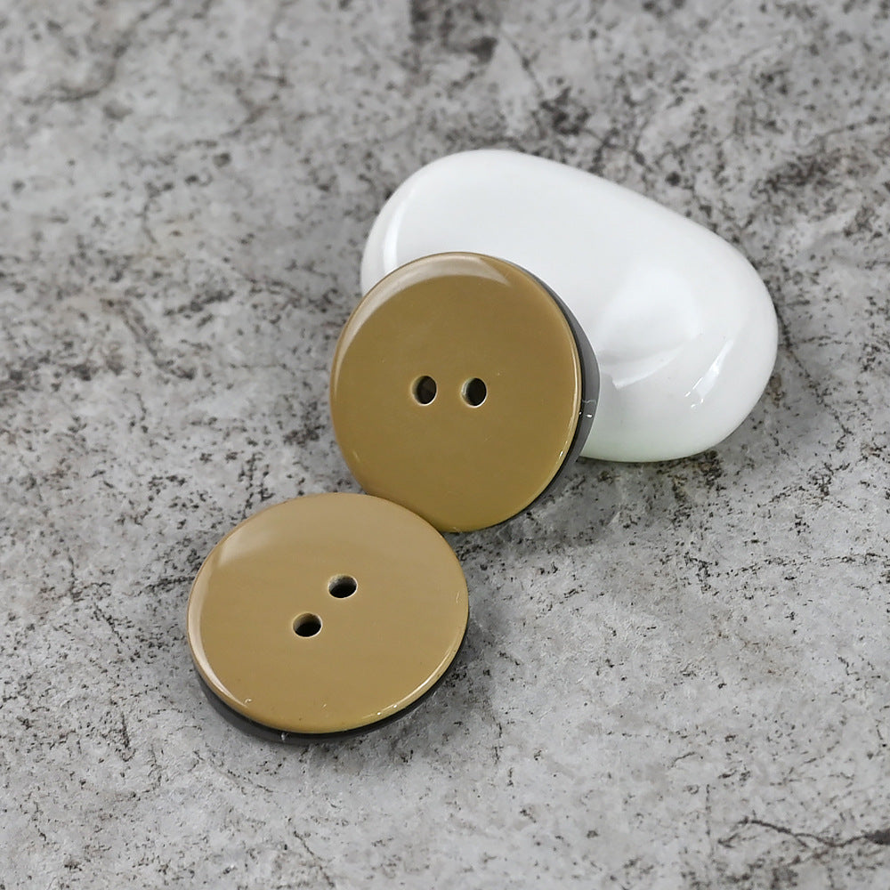 Two-hole resin buttons in pale gold/cream, round with two holes