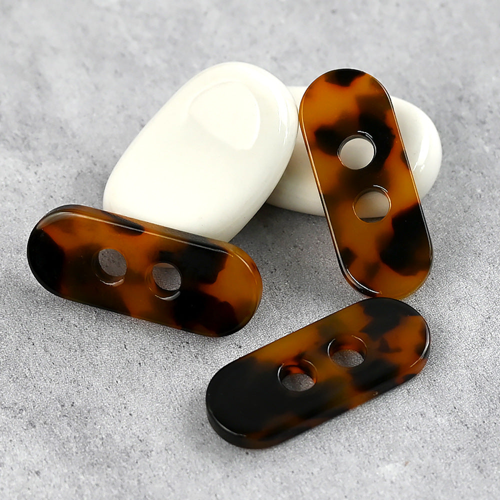 Long strip resin buttons in coffee-amber tones, flat, each with two holes