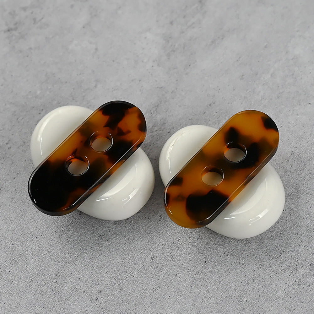 Two long strip resin buttons with coffee-amber faces and two holes; white backs