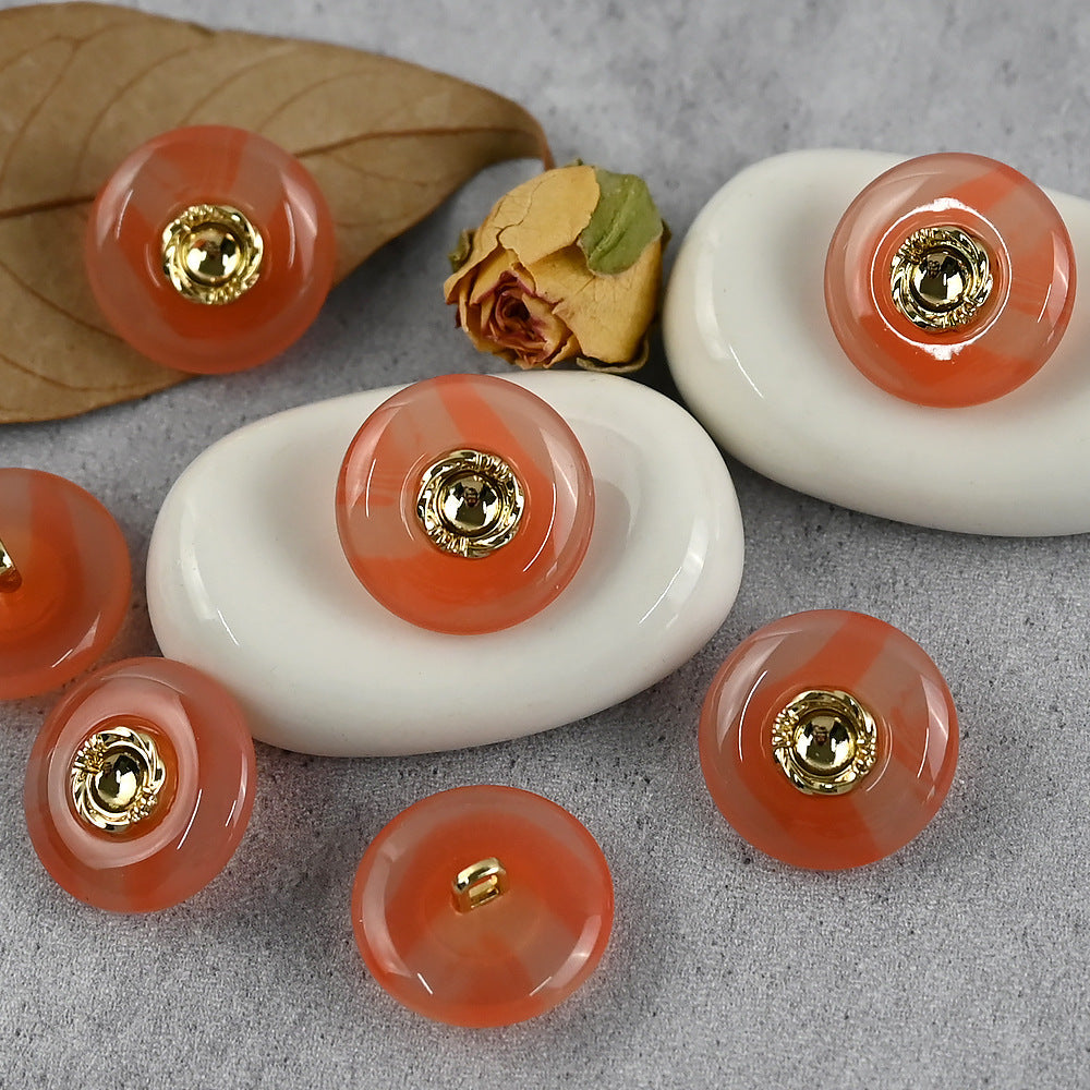 Orange and white resin buttons with gold-tone metal shanks and round center cap