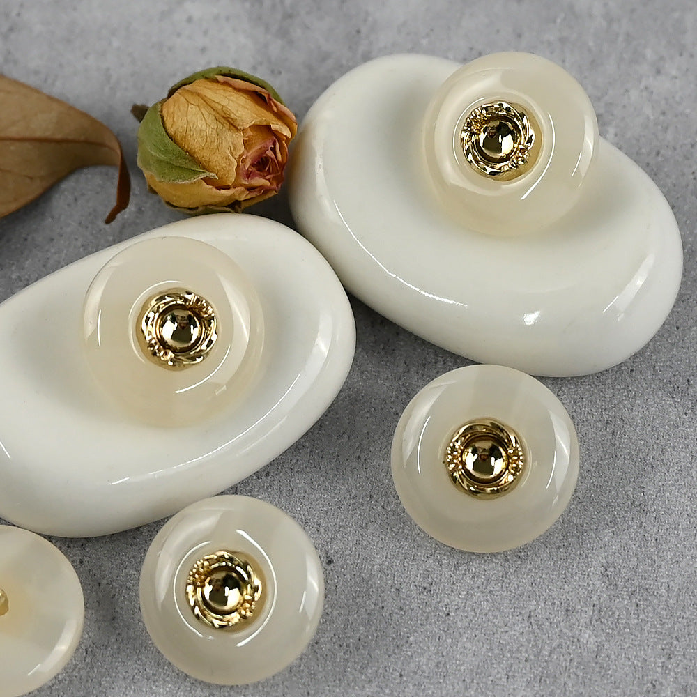 White resin buttons with gold-tone metal shanks and round gold center cap