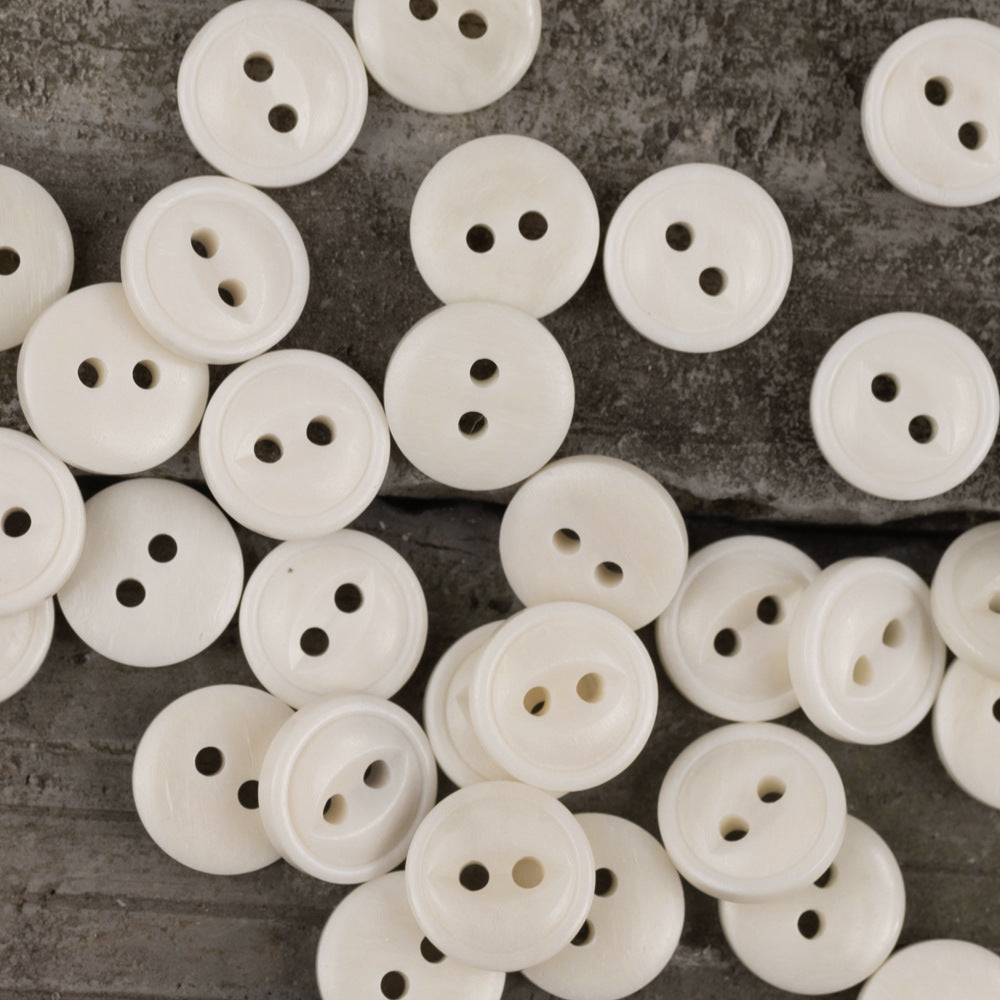 Close-up of ivory round two-hole fish-eye buttons, 11.5mm