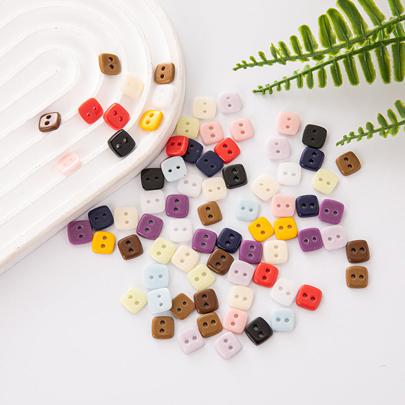 Square 2-hole ceramic buttons, mixed pastel and dark colors on tray and flat lay