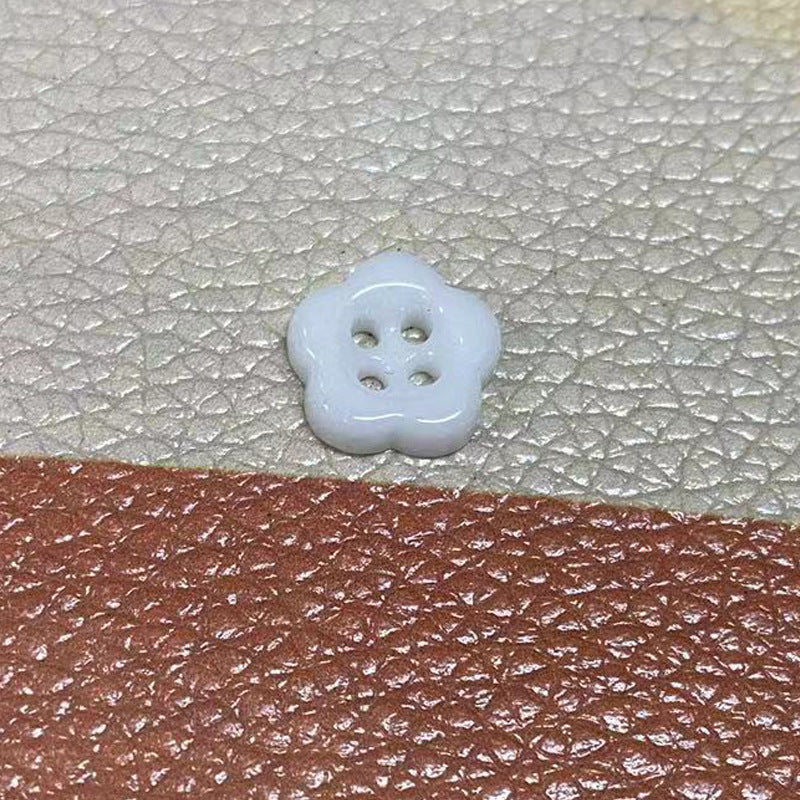 Light blue four-hole flower ceramic button, close-up on front